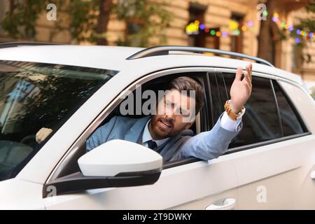 Autista stressato che guarda fuori dall'auto nel traffico Foto Stock