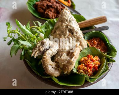 Ingkung Ayam, un cibo tradizionale di Yogyakarta, Indonesia, preparato con un pollo intero bollito con spezie e latte di cocco. Foto Stock