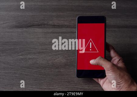 Icona di avvertenza dello smartphone con triangolo. Spazio di copia per il testo. Concetto di errore di sistema, malware e cyber crimine. Foto Stock
