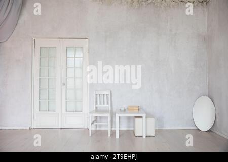 Interno di una camera bianca senza persone con sedia e specchio Foto Stock