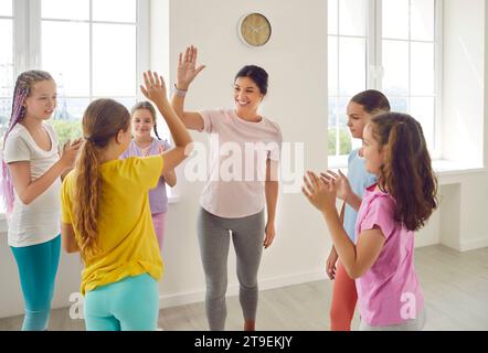 Happy dance sport trainer che dà cinque figli al termine della lezione in studio di coreografia. Foto Stock