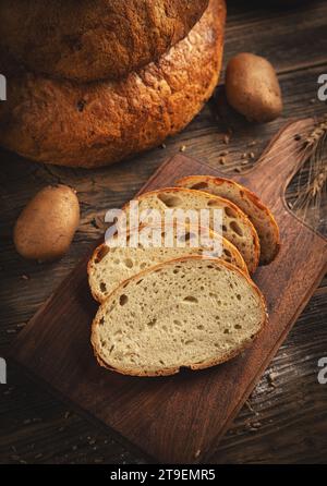 Pane appena sfornato in un ambiente rustico. Pane a fette di pasta madre Foto Stock