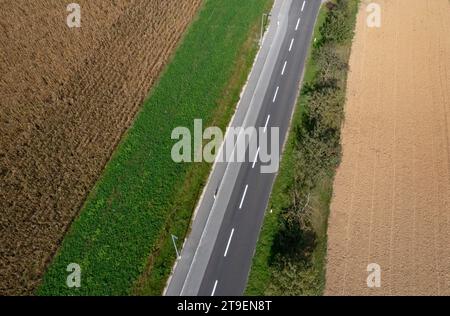 Vista droni di una strada di campagna tra campi raccolti, Hofkirchen im Traunkreis, alta Austria, Austria Foto Stock