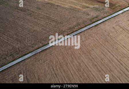 Vista droni di una strada di campagna tra campi coltivati e verdi, Innviertel, alta Austria, Austria Foto Stock