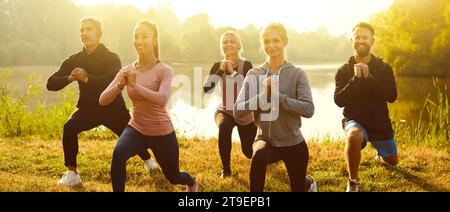 Gruppo di persone in forma e attive che fanno esercizio di stretching in natura. Concetto di fitness all'aperto. Foto Stock