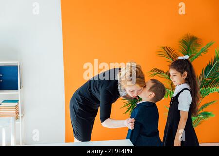 I bambini si congratulano con l'insegnante per le vacanze a scuola Foto Stock