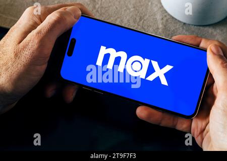 Logo HBO Max sullo schermo del telefono cellulare su un tavolo. Uomo con uno smartphone e l'app si apre. Rosario, Argentina - 23 novembre 2023. Foto Stock