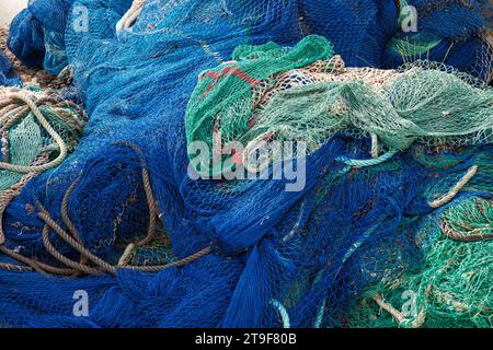 Blue and green nylon fishing net in harbor.  Commercial fishing industry Foto Stock