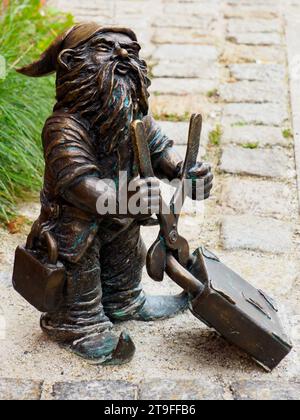 Wrocław, Polonia - settembre 2022: Nano con lucchetto vicino al ponte. Piccole figure in bronzo di gnomi per le strade di Breslavia. Europa Foto Stock