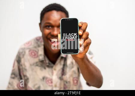 Ritratto dell'uomo che tiene la mano con gli sconti del Black friday sullo schermo. Foto Stock