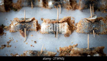 Sardine arrotolate al forno con condimento di pinoli, pangrattato, uva passa, sale e pepe. Cucina tipica siciliana. Buon cibo a base di pesce Foto Stock