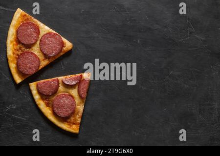 Due pezzi di pizza al peperone, su sfondo scuro, vista dall'alto, spazio per copiare il testo. Foto Stock