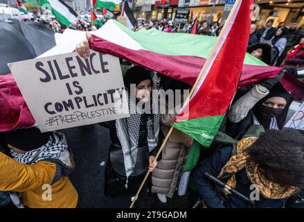 Frankfur am Main, Germania. 25 novembre 2023. "Il silenzio è complicità” è scritto sul poster di una manifestazione pro-palestinese nel centro di Francoforte. Il raduno era accompagnato da una massiccia presenza della polizia. Credito: Boris Roessler/dpa/Alamy Live News Foto Stock