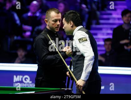 Mark Allen (a sinistra) stringe la mano a Ding Junhui il primo giorno del MRQ UK Championship 2023 a York Barbican. Data immagine: Sabato 25 novembre 2023. Foto Stock