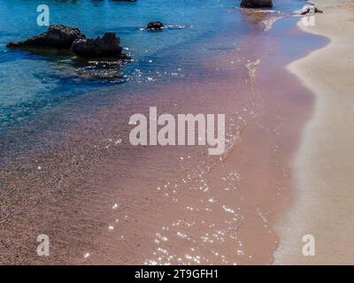 Una vista della sabbia rosa che si trova sulla spiaggia di Elafonissi, Creta, in una luminosa giornata di sole Foto Stock