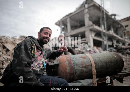 25 novembre 2023: Deir al-Balah, Striscia di Gaza, Palestina. 24 novembre 2023. I palestinesi siedono tra le macerie della loro casa distrutta a Deir al-Balah, durante una tregua dopo 7 settimane di incessanti bombardamenti israeliani. Venerdì 24 novembre è iniziata una tregua umanitaria di quattro giorni tra Israele e Hamas, con gli sfollati di Gaza che visitano le loro case e valutano i danni causati dai continui scioperi israeliani. Tuttavia, ai palestinesi sfollati nella Gaza meridionale non è stato permesso di viaggiare verso nord per valutare i danni alle loro case e proprietà (Credit Image: © Adel al Hwajre/IMAGESLIVE via ZUMA Press Wire) e Foto Stock