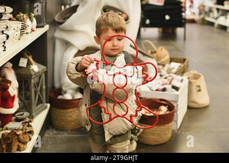 Un bambino sceglie decorazioni a forma di uomo di pan di zenzero Foto Stock