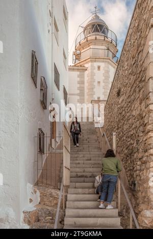 Donne che salgono e scendono le scale per salire il faro di Peñíscola situato accanto al Castello ed è il Centro accoglienza visitatori di Castello, Spagna. Foto Stock