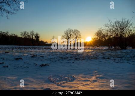 Sonnenuntergang auf einer verschneiten Wiese Nähe Baden-Baden Foto Stock