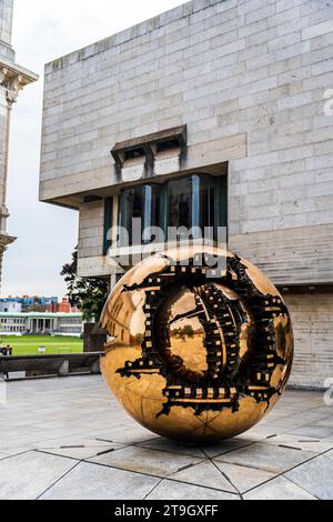 Berkeley Library con la scultura di Arnaldo Pomodoro chiamata Sphere withing Sphere, nel campus del Trinity College, nel centro di Dublino, in Irlanda Foto Stock