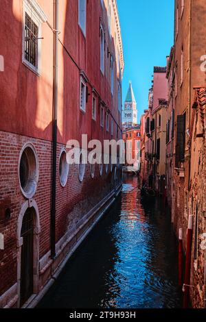 Venezia, Italia - 9 novembre 2023: Torre Campanile e stretto canale a Venezia, colorata e antica architettura della città Foto Stock