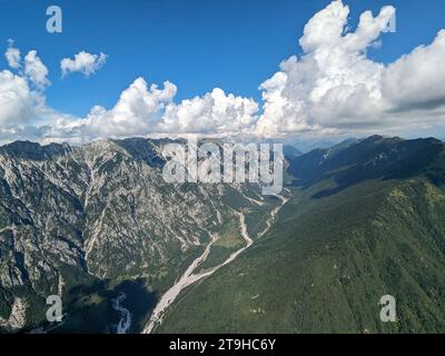 Parapendio bellezza del volo libero nelle Alpi Giulie, grandi montagne che volano alla base nuvolosa delle nuvole di cumulus, panorama panoramico aereo, Sloven Foto Stock