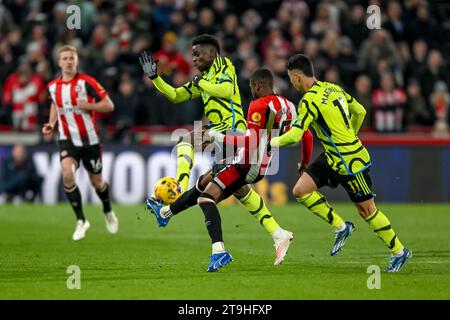 Bukayo Saka dell'Arsenal FC e Frank Onyeka del Brentford FC sfidano il pallone durante la partita di Premier League tra Brentford e Arsenal al Gtech Community Stadium, Londra, Inghilterra il 25 novembre 2023. Foto di Phil Hutchinson. Solo per uso editoriale, licenza necessaria per uso commerciale. Nessun utilizzo in scommesse, giochi o pubblicazioni di un singolo club/campionato/giocatore. Credito: UK Sports Pics Ltd/Alamy Live News Foto Stock