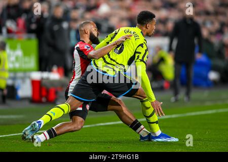 Frank Onyeka del Brentford FC e Gabriel dell'Arsenal FC si sfidano per il pallone durante la partita di Premier League tra Brentford e Arsenal al Gtech Community Stadium, Londra, Inghilterra il 25 novembre 2023. Foto di Phil Hutchinson. Solo per uso editoriale, licenza necessaria per uso commerciale. Nessun utilizzo in scommesse, giochi o pubblicazioni di un singolo club/campionato/giocatore. Credito: UK Sports Pics Ltd/Alamy Live News Foto Stock