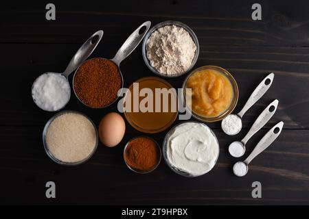 Ciambelle di sidro di mele al forno ingredienti su un tavolo di legno: Salsa di mele, yogurt greco e altri ingredienti per creare una ricetta di ciambelle più sana Foto Stock