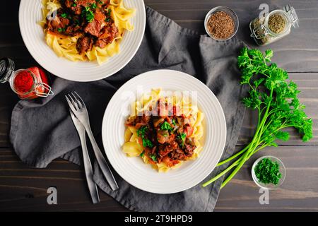 Goulash tedesco servito su tagliatelle di uova in bocce poco profonde: Pezzi di manzo bolliti conditi con marjoram, semi di carvi e paprika Foto Stock