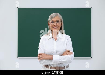 Ritratto di professore felice vicino alla lavagna in classe Foto Stock