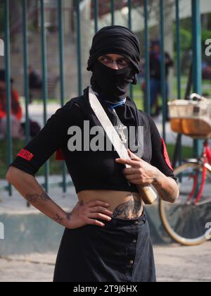 Lima, Perù. 25 novembre 2023. Donna mascherata di colore nero che porta una lama, simboleggia la violenza, quando centinaia di donne sono scese per la strada di Lima nell'ambito delle attività della giornata internazionale per l'eliminazione della violenza contro le donne, evento che viene commemorato annualmente il 25 novembre, la data in cui le tre sorelle Mirabal (Patria, Minerva e María Teresa) furono uccise. Nella Repubblica Dominicana su 1960. Credito: Agenzia stampa Fotoholica/Alamy Live News Foto Stock