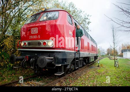 Oldenburg, Germania. 15 novembre 2023. Roland Sandkuhl, un macchinista autonomo di Oldenburg, guarda fuori dalla cabina del macchinista della sua locomotiva diesel 1965 DB serie V 169. Sandkuhl ha avviato la propria attività come macchinista e guida la propria locomotiva sui servizi merci in tutta la Germania. Credito: Hauke-Christian Dittrich/dpa/Alamy Live News Foto Stock