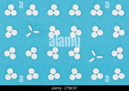 Pillole bianche su sfondo blu. Primi piani di pillole oblunghe e rotonde. Sanità e medicina Foto Stock