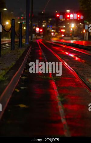 Una notte piovosa con luci di arresto che si riflettono sulle strade e i binari di Portland, Oregon, Stati Uniti Foto Stock