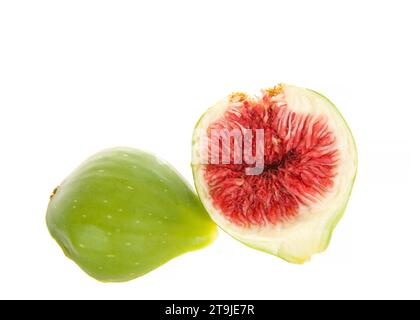 Fichi freschi spaccati a metà prima della maturazione, frutta non matura gonfia isolata su fondo bianco. Una metà mostra l'interno, l'altra metà l'esterno verde Foto Stock