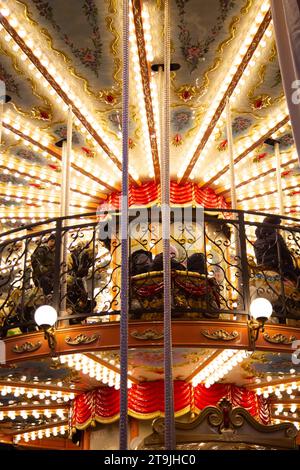 Un primo piano di una giostra decorata con belle luci al mercatino di Natale (Wiener Christkindlmarkt) di notte in inverno, Rathause, Vienna, Austr Foto Stock