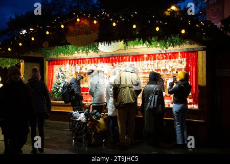 Venditori ambulanti che vendono decorazioni natalizie e visitatori affollati al mercatino di Natale (Wiener Christkindlmarkt) di sera d'inverno, Vienna Foto Stock