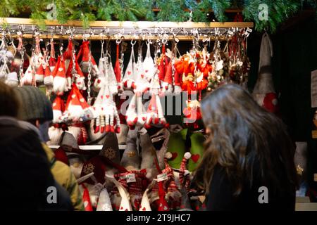 Venditori ambulanti che vendono decorazioni natalizie e visitatori affollati al mercatino di Natale (Wiener Christkindlmarkt) di sera d'inverno, Vienna Foto Stock