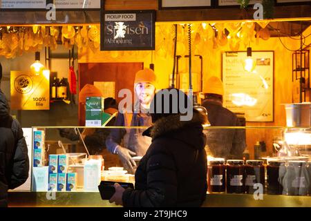 Outlet che vende bevande calde visitato dagli acquirenti al mercatino di Natale (Wiener Christkindlmarkt) di notte in inverno, Rathause, Vienna, Austria Foto Stock