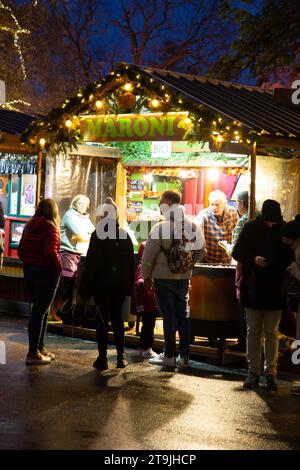 Un locale di Street food affollato di visitatori al mercatino di Natale (Wiener Christkindlmarkt) di notte in inverno, Rathause, Vienna, Austria Foto Stock
