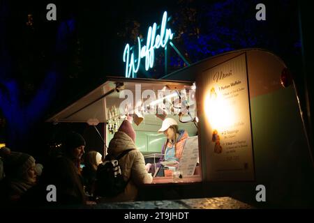 Negozio di vendita di cialde (Waffeln) e visitatori affollati al mercatino di Natale (Wiener Christkindlmarkt) la sera d'inverno, Vienna Foto Stock