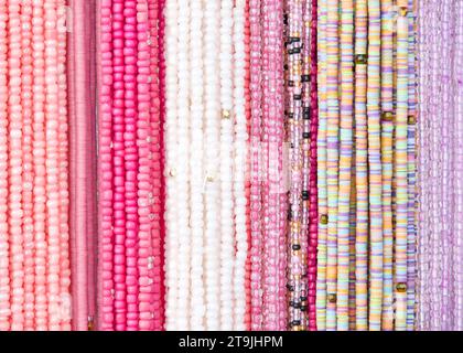 primo piano su corde di perline in rosa e viola. Decorazioni per capelli popolari in alcune culture. Foto Stock