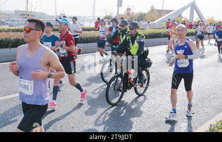 SHANGHAI, CINA - 26 NOVEMBRE 2023 - i corridori gareggiano nella Shanghai International Marathon a Shanghai, Cina, 26 novembre 2023. Foto Stock