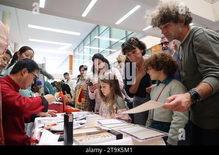 Rabat, Marocco. 25 novembre 2023. I visitatori assistono a una dimostrazione di calligrafia cinese durante un bazar di beneficenza a Rabat, in Marocco, il 25 novembre 2023. Crediti: Huo Jing/Xinhua/Alamy Live News Foto Stock