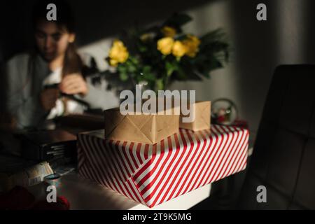 Regali di Natale sul tavolo. Preparazione della confezione regalo per le vacanze Foto Stock