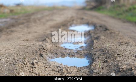 Sparatoria su strada fangosa da terra. Paesaggio di campagna con una via fangosa. Strada fangosa con sentiero per ruote. Foto Stock