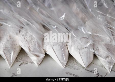 Un gran numero di bustine trasparenti riempite di polvere bianca. Polvere bianca confezionata in bustine piccole. Foto Stock