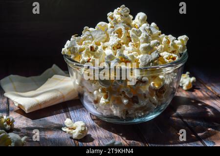 Una pila di popcorn salati, in un recipiente di vetro, messa a fuoco selettiva. Foto Stock