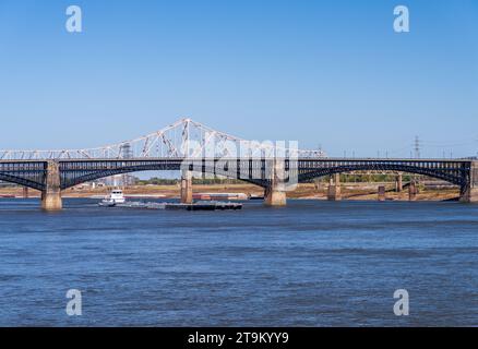 Potente rimorchiatore a spinta con chiatte di prodotti petroliferi sotto l'Eads Bridge a St Louis, Missouri Foto Stock